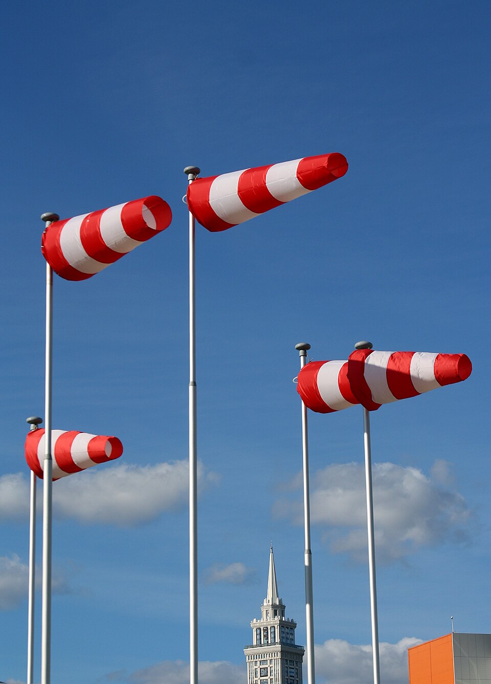 Several red-and-white windsocks extended on tall poles against a blue sky.