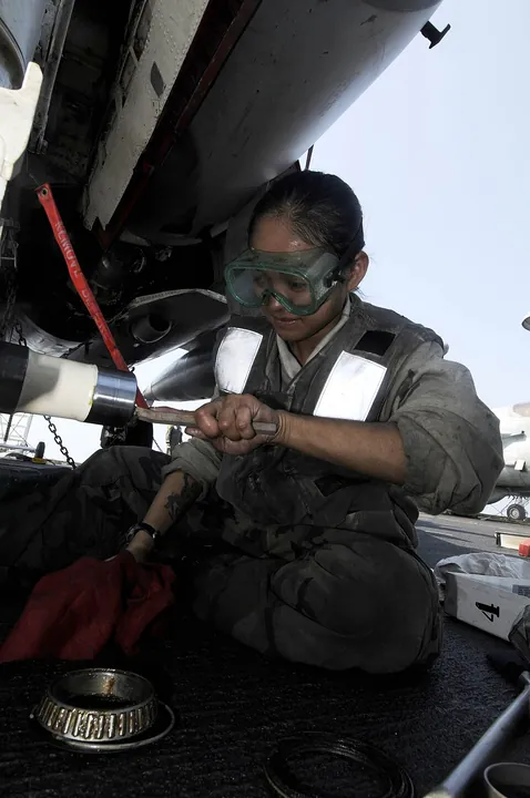A technician maintains an aircraft nose landing gear.