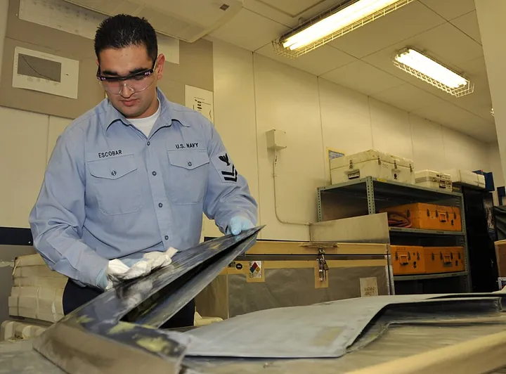 A technician prepares a helicopter tip-cap surface for composite repair.