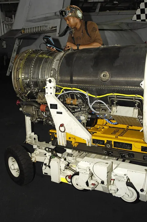 A technician inspects inside an aircraft engine with a borescope.