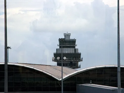 Hong Kong International Airport backup control tower above terminal roofs.