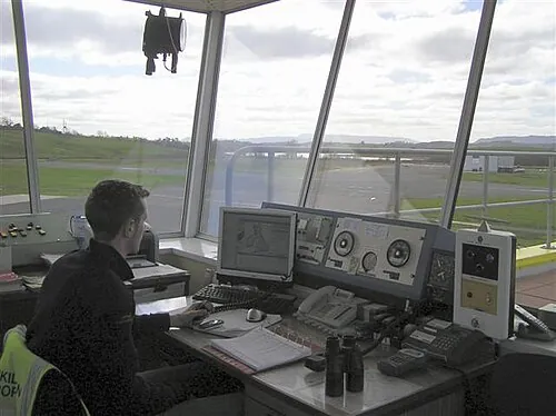 Controller seated at instruments and windows in St Angelo Airport's tower.