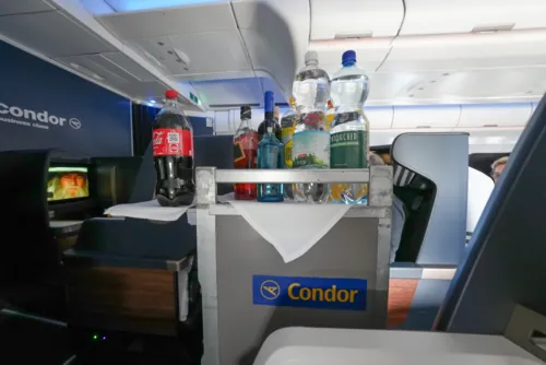 A Condor service cart in an aircraft cabin.