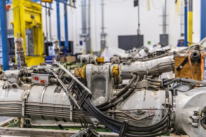 Landing-gear assemblies occupy a maintenance workshop.