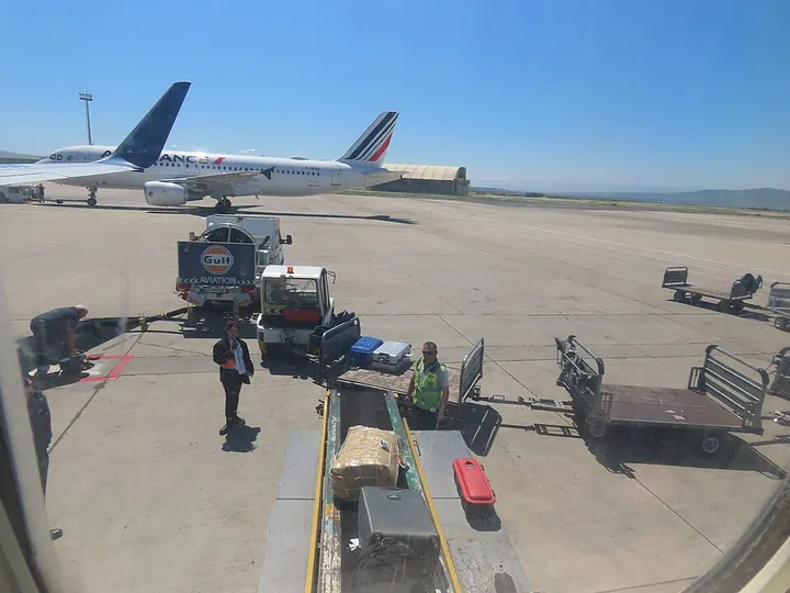 Luggage being unloaded using a belt loader at Tbilisi Airport