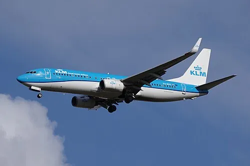 KLM Boeing 737 in flight with landing gear extended and wing devices visible.
