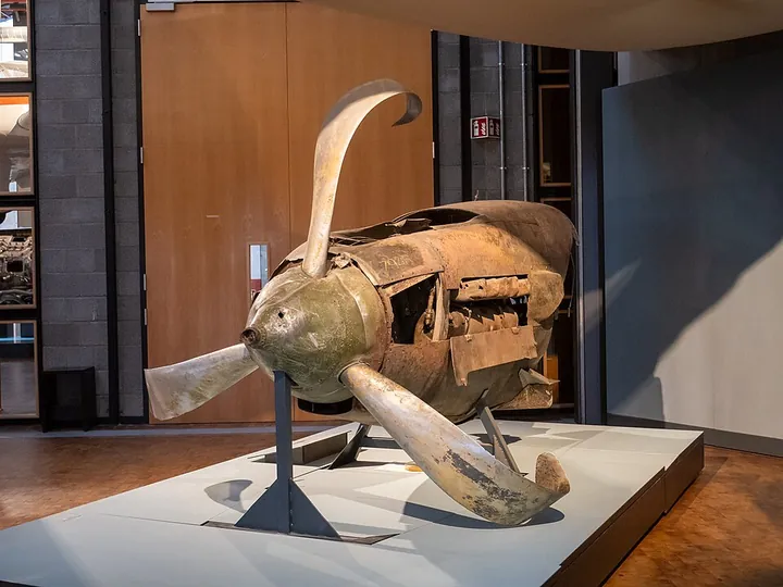 A damaged aircraft engine is displayed in a technology museum.