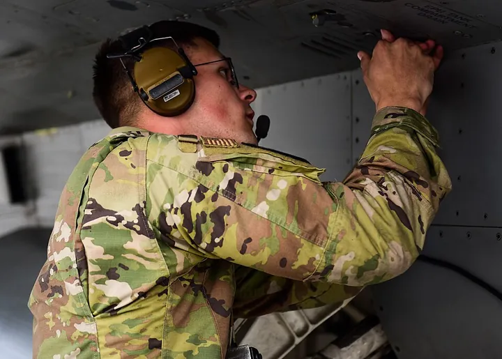 A crew chief checks hydraulic-system indications after an aircraft lands.