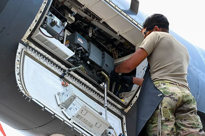 A technician replaces a coolant quick-disconnect on an aircraft.