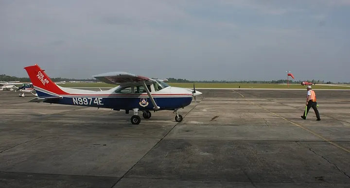 A marshaller guiding a Civil Air Patrol Cessna 182 into parking at Keystone Heights Airport