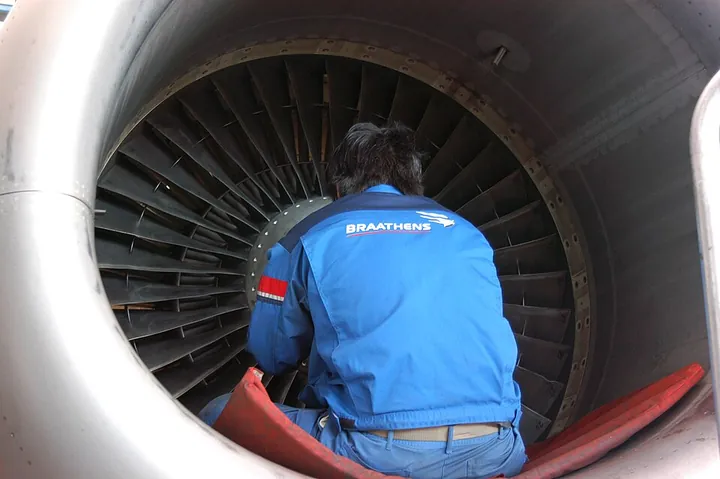 A Braathens Teknik employee inspecting a CFM56 turbofan engine.