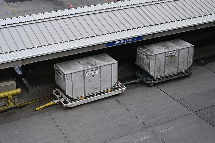 Two LD8 cargo containers on dollies at Boston Logan Airport