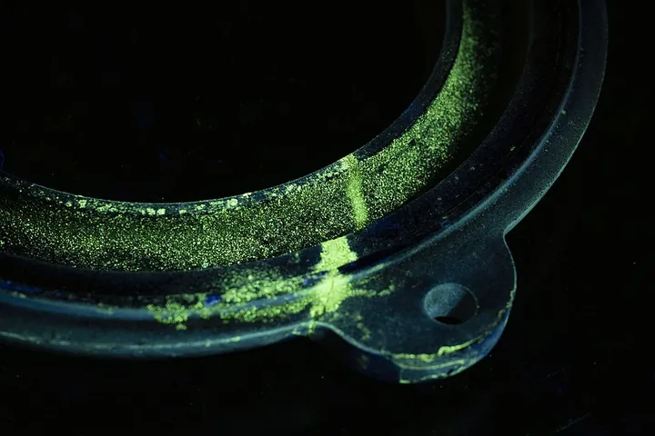 A mechanical component is examined under ultraviolet light.
