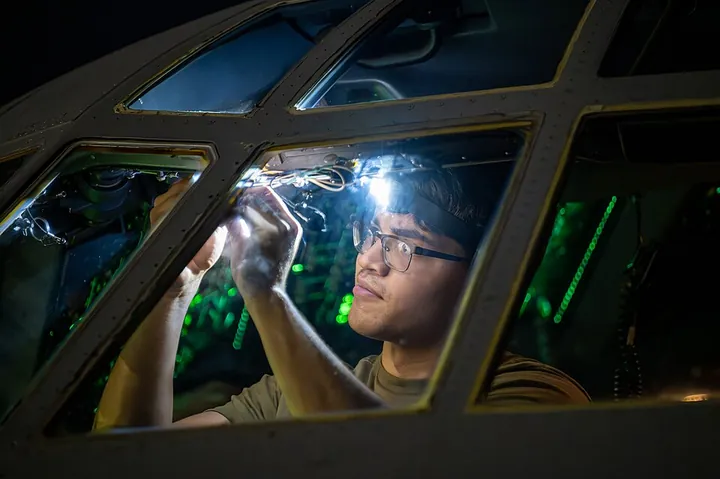A specialist works on aircraft electrical systems during an exercise.