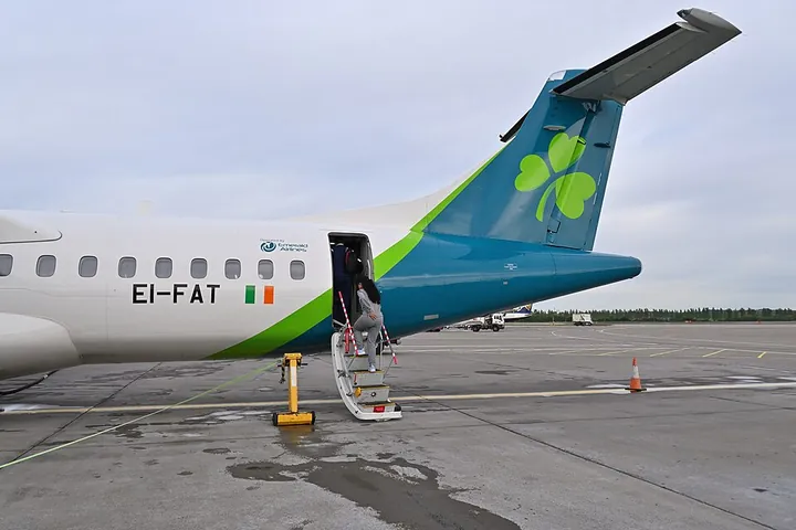 Passengers boarding an ATR 72-600 through its rear doorway at Edinburgh Airport