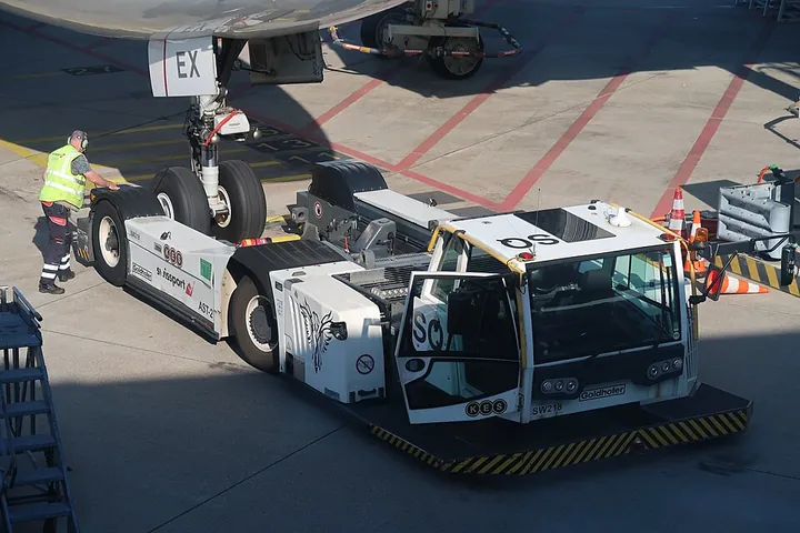 A pushback tractor preparing to move a Qatar Airways Boeing 777 at Amsterdam Schiphol