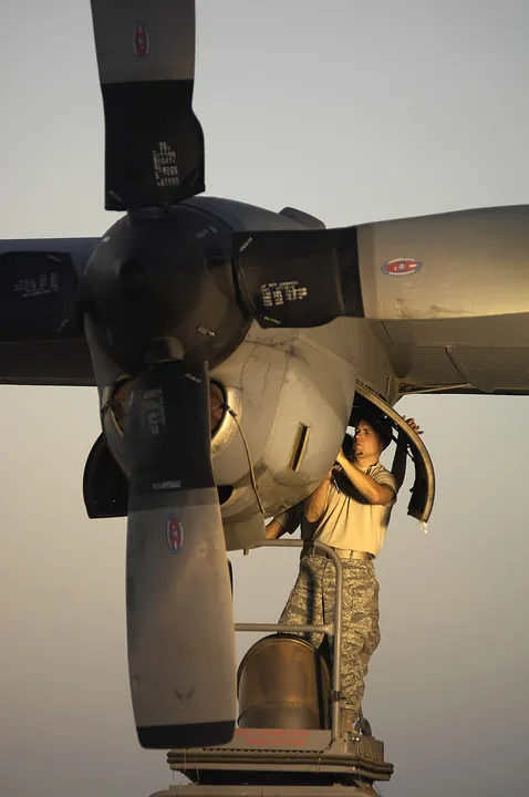 A technician uses a borescope to examine an engine turbine.