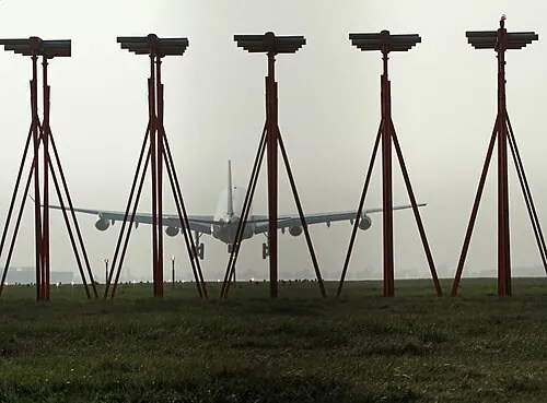 A Boeing 767 seen beyond a foreground row of localizer antennas.