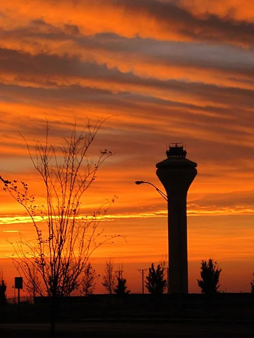 Memphis airport control tower silhouetted against an orange sunrise.