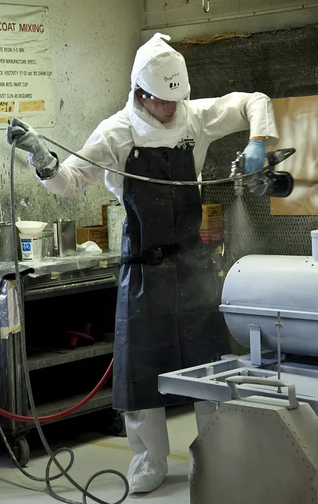 A maintenance student applies a coating to an aircraft component.