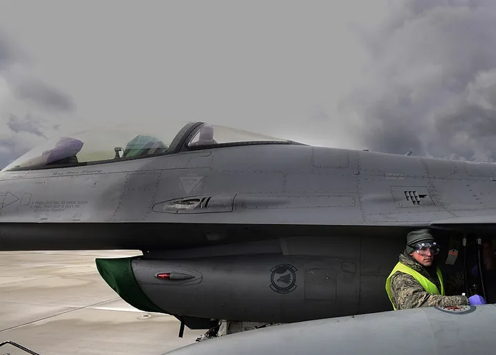 A crew chief drains hydraulic fluid from an aircraft.