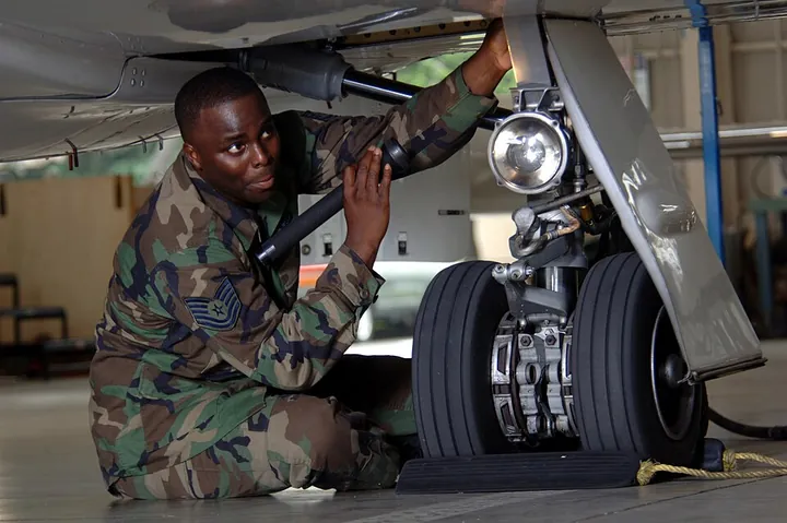 A technician checks a C-21 landing gear during a quality-assurance inspection.