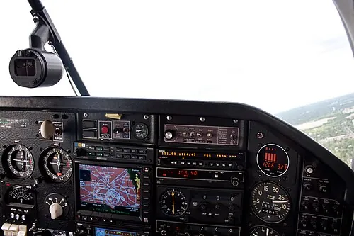 Mooney M20J panel with round gauges, radio equipment and a color display.