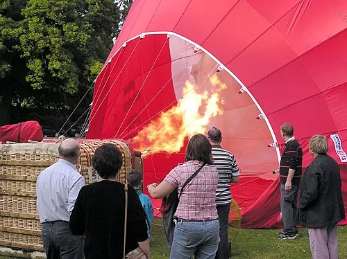 Burners producing flames beneath a partially inflated balloon envelope.