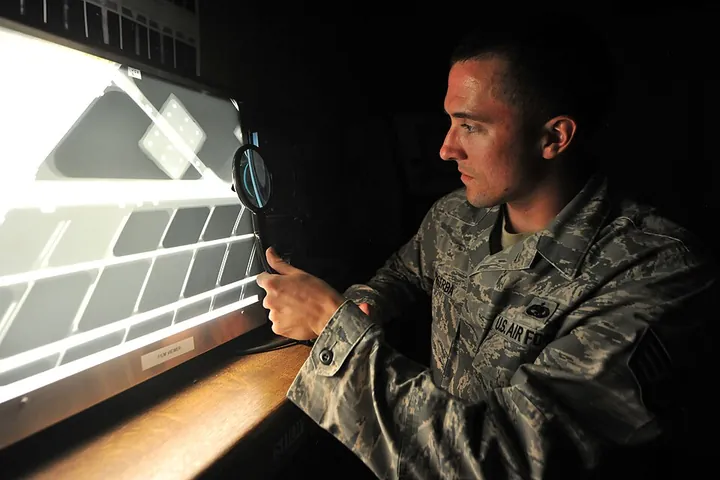 A technician studies a radiographic image of an aircraft structure.
