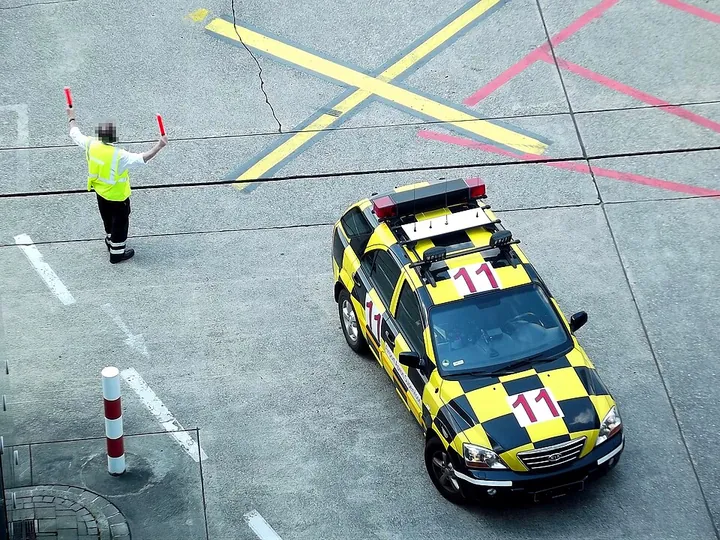 A marshaller and follow-me vehicle at Düsseldorf Airport