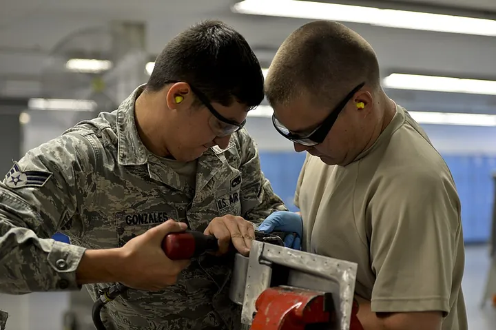 Two structural technicians install rivets on a C-130.