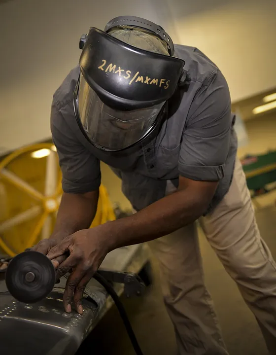A technician removes damaged skin from a wing flap.