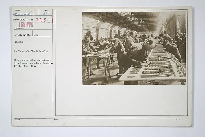 Workers join wing ribs in an early aircraft factory.