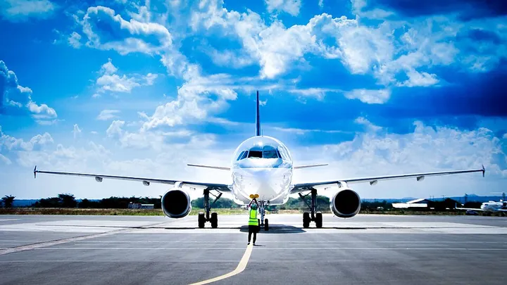A marshaller guiding a Qatar Airways Airbus A320 at Kilimanjaro International Airport