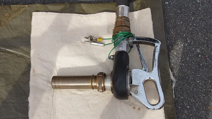An aircraft fuel nozzle displayed with a Japanese Air Self-Defense Force refuelling truck