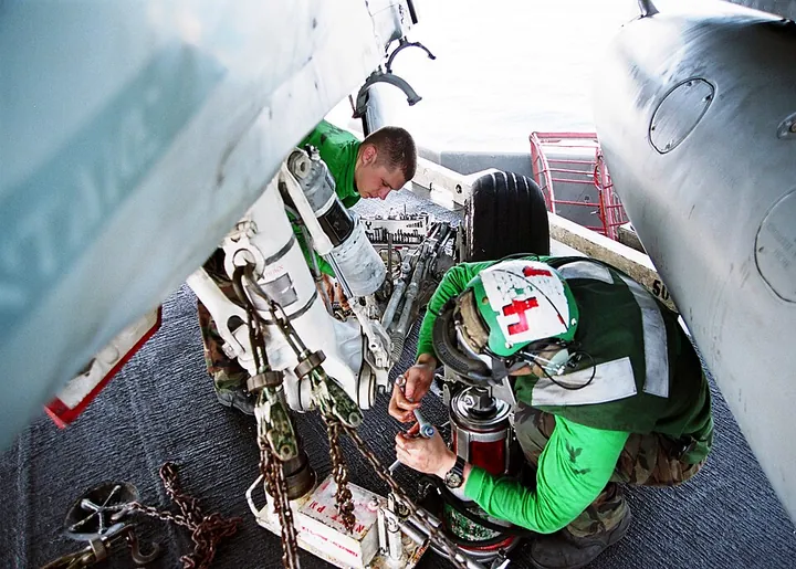 Technicians maintain a landing-gear shock absorber.