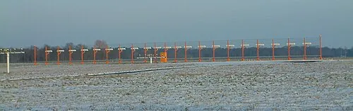 Long row of localizer antennas beside runway 27R at Hanover Airport.