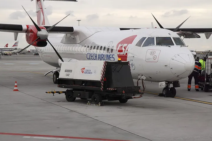 A Czech Airlines ATR 72 connected to a ground power unit at Prague Airport