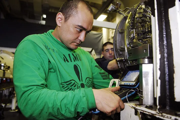 A technician checks an engine fan module for internal damage before maintenance.