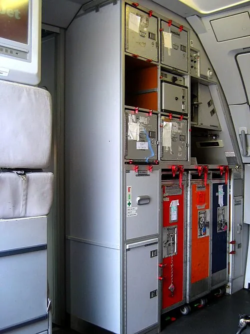 A compact forward galley with storage compartments and service equipment.