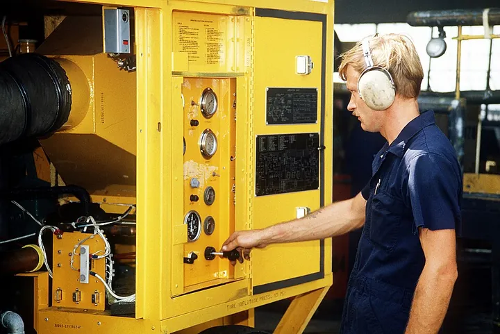 A support-equipment technician tests a mobile air-conditioning unit.